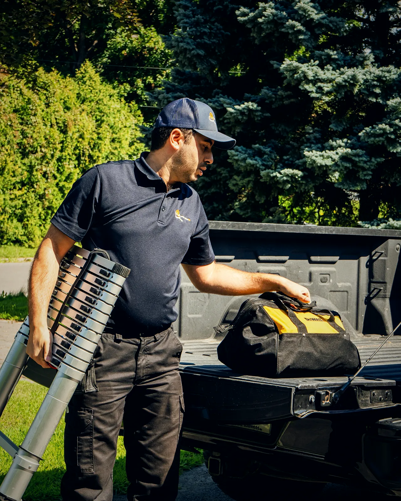 An Inspection AZ inspector unloading a ladder and an instrument case from the truck before a visit.